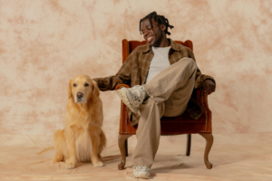 Human sitting next to a golden retriver